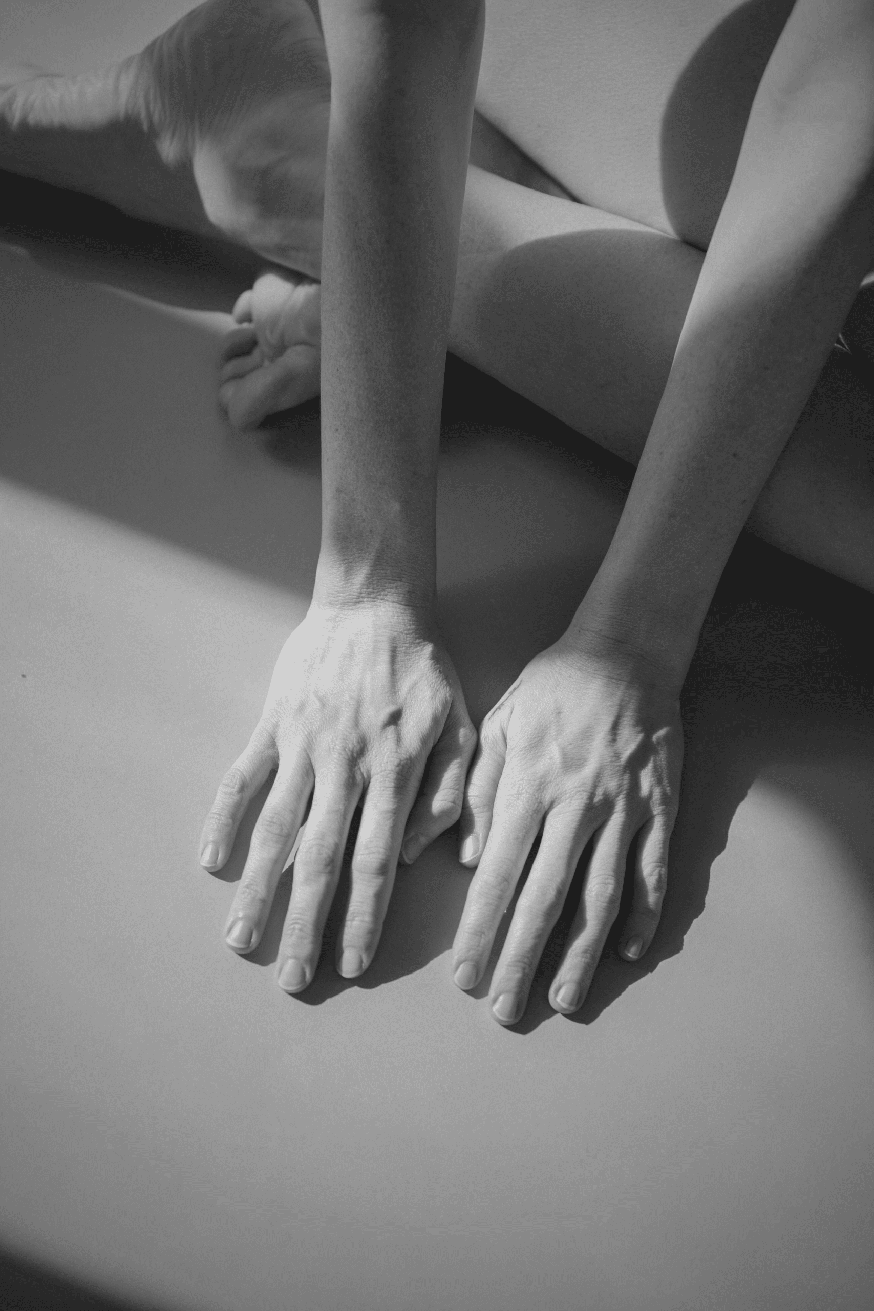 Mani femminili in appoggio su una superficie, in bianco e nero.