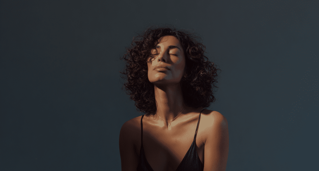 Donna che pratica la mindfulness seduta con gli occhi chiusi